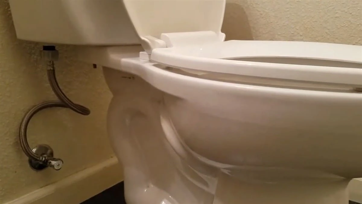 Toilet installation in Fresno, CA with code-compliant angle stop, braided stainless steel supply line, and properly aligned tank-to-bowl connection.