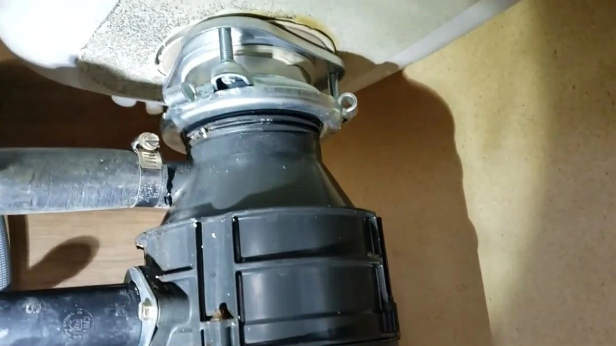 Garbage disposal repair under kitchen sink in clovis ca showing mounting assembly and drain connection