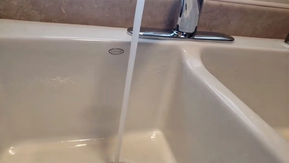 New Kohler drop-in kitchen sink installation in Clovis CA featuring a chrome faucet with steady water flow.